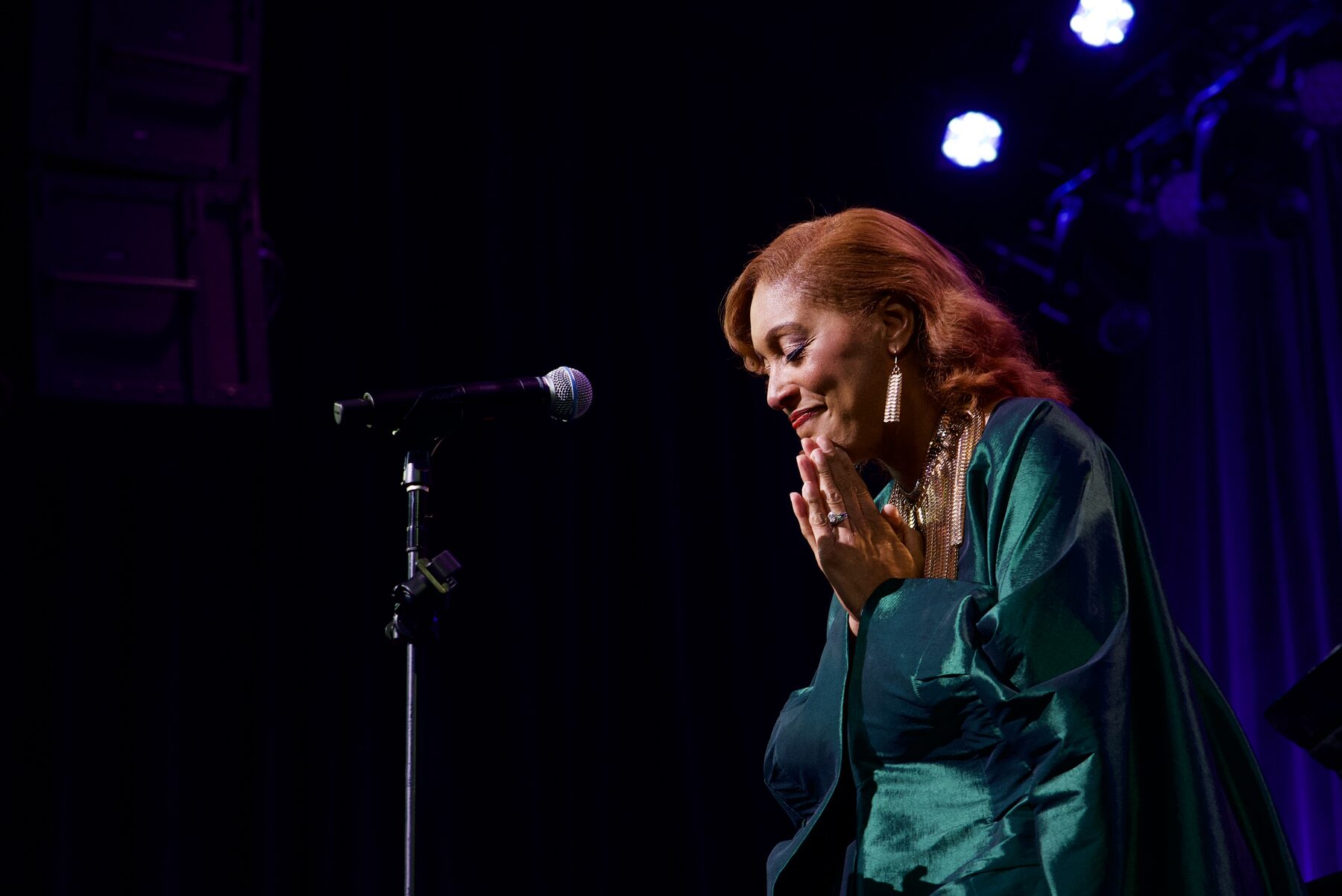 Featured vocalist in a moment of prayer at the microphone