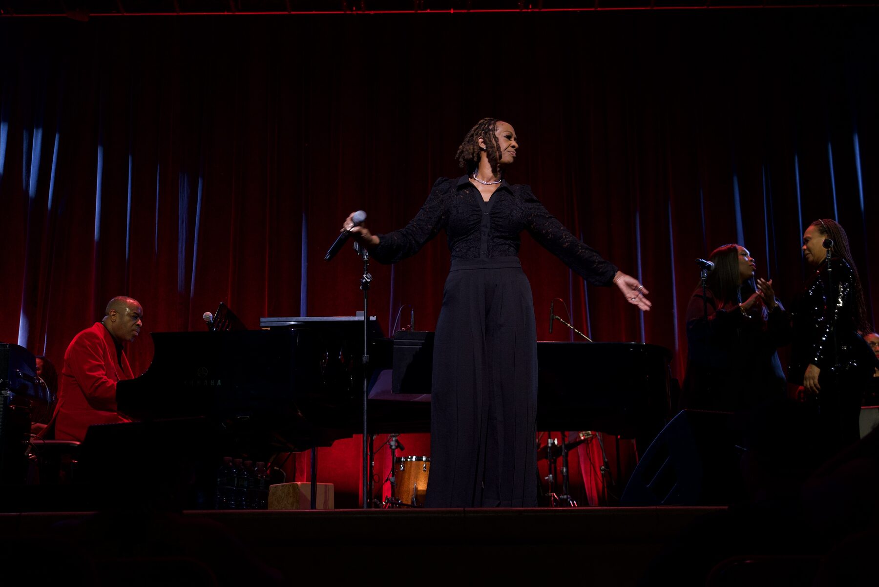 Vocalist performing as Damien Sneed plays piano